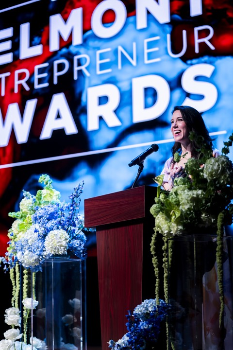 A speaker at the podium under the Belmont Entrepreneur Awards screen