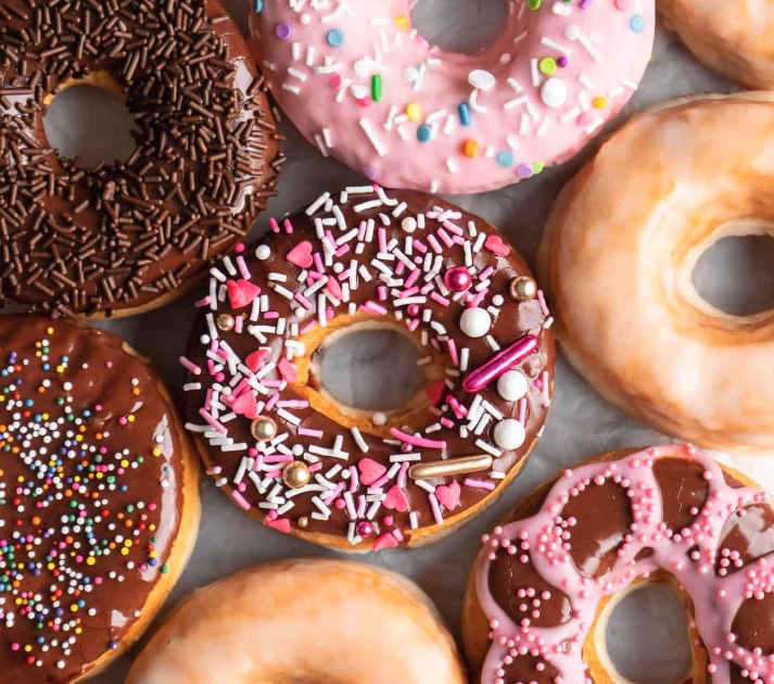 Close-up of iced doughnuts with chocolate, pink icing and sprinkles
